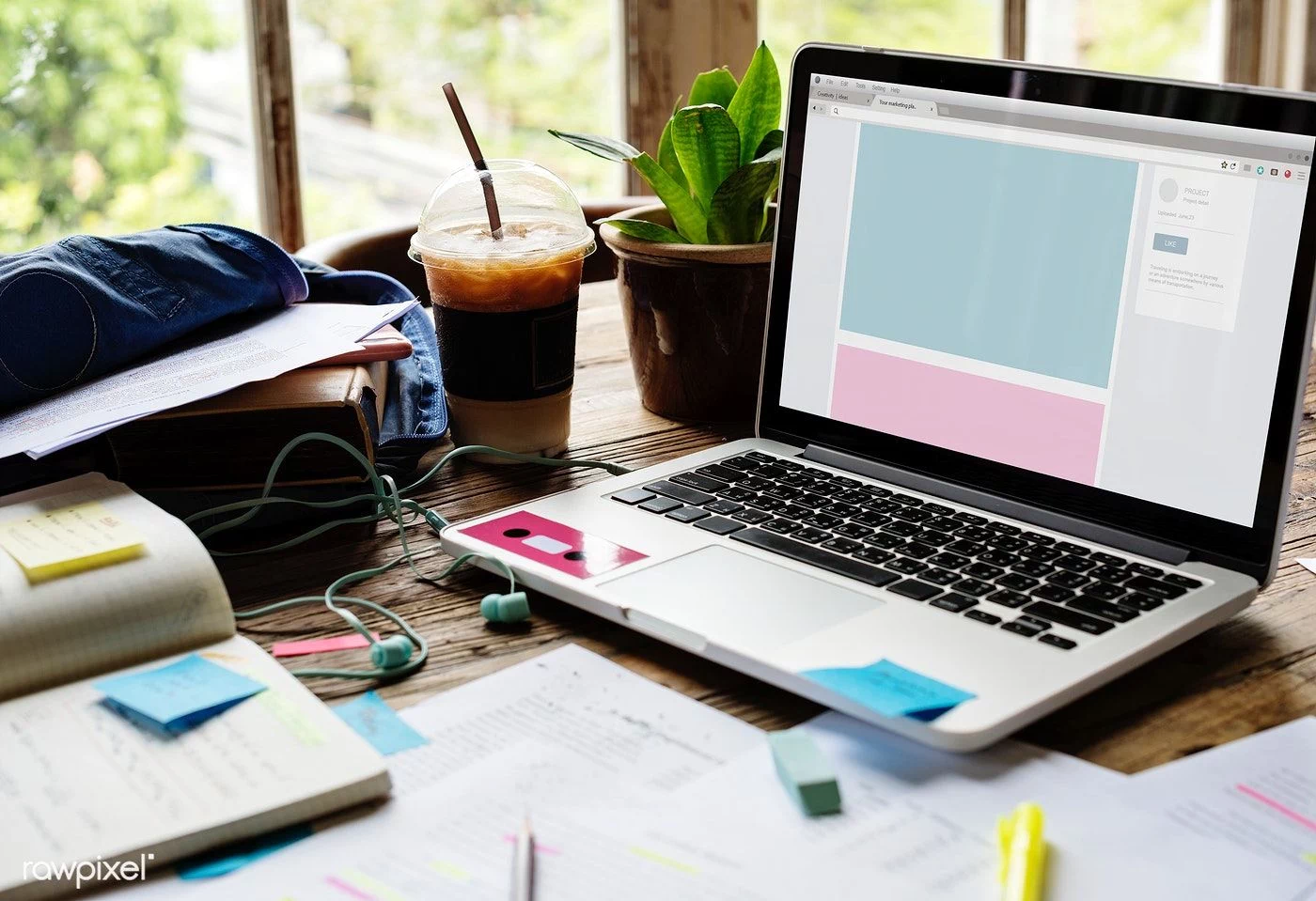 Laptop, sticky notes, notes, and smoothies on the desk.