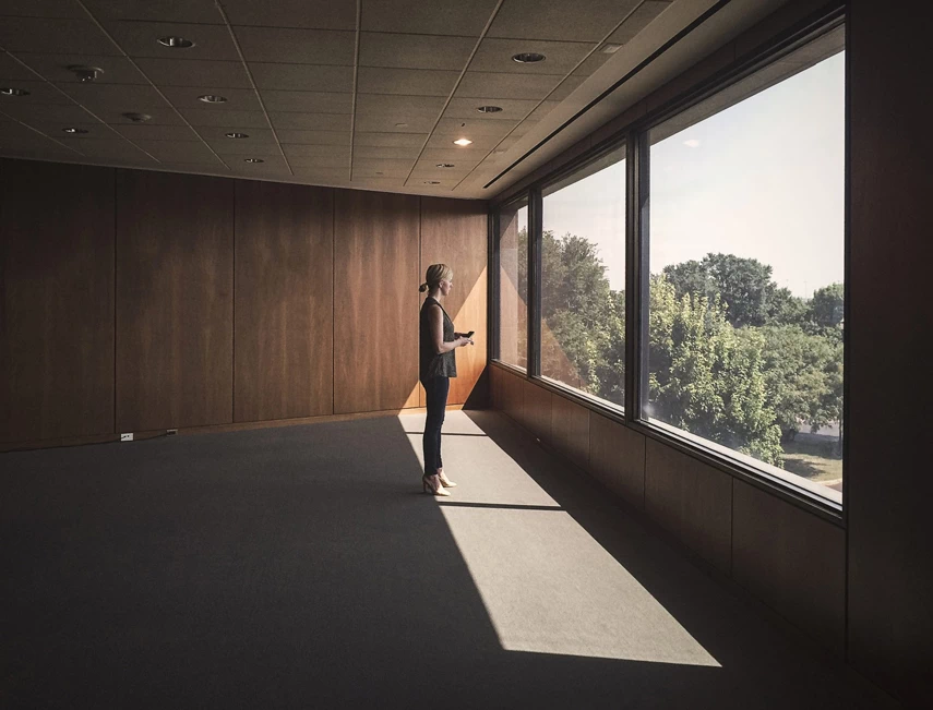 Girl in empty room watch in huge windows.
