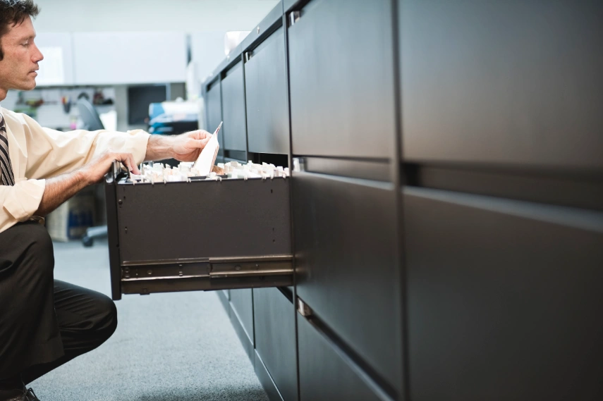 Businessman-pulling files from a traditional drawers