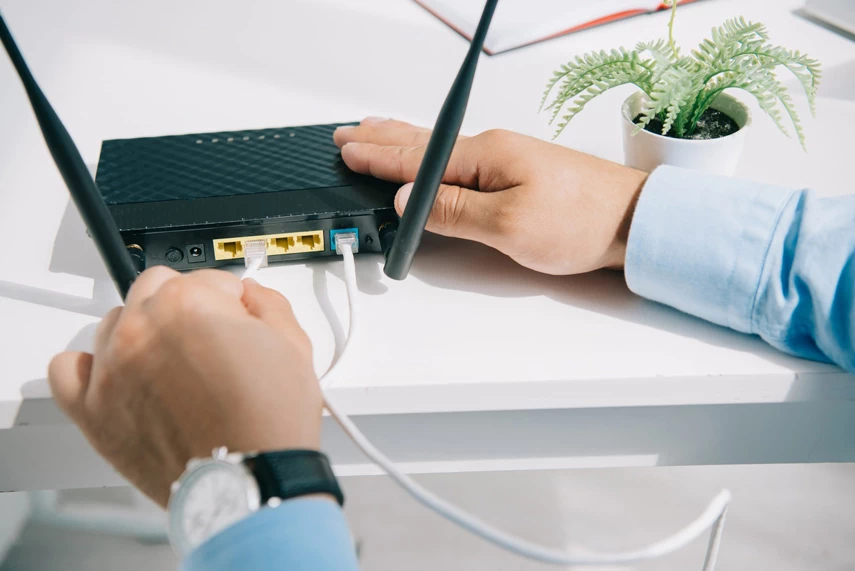 Man connect RJ-45 cabels in the router.