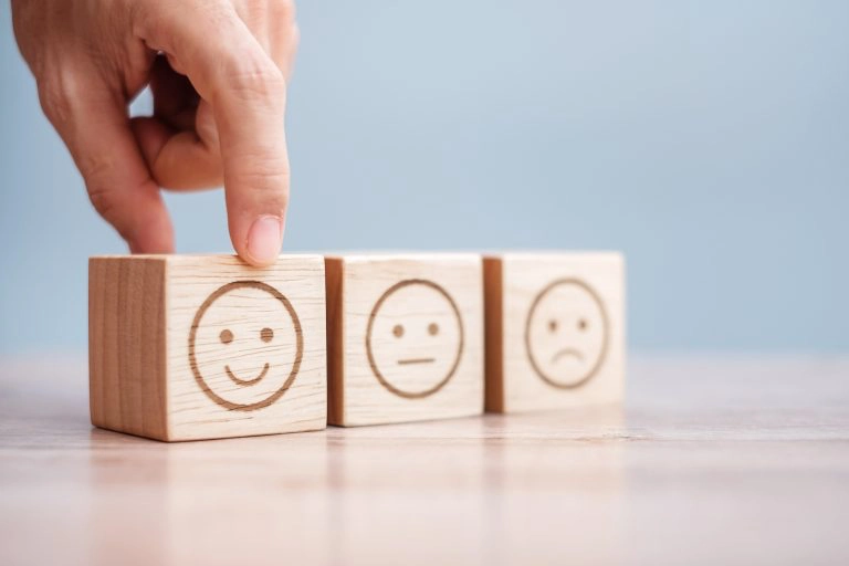 Man hand holding emotion face blocks.