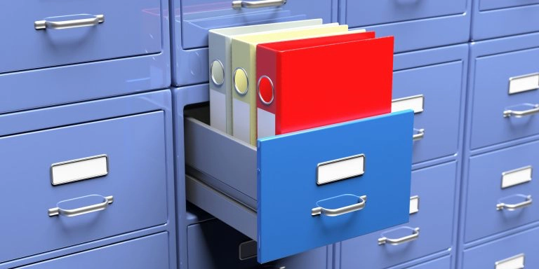 Office document binders in a filing cabinet drawer.