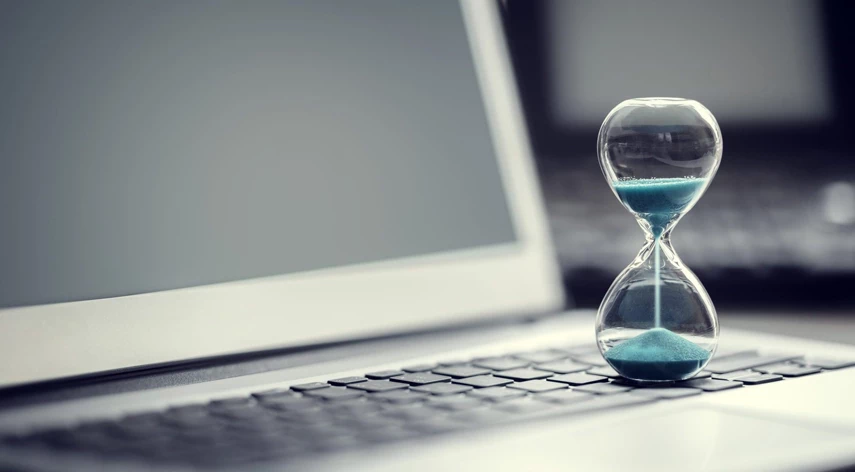 Sand clock standing on the laptop.