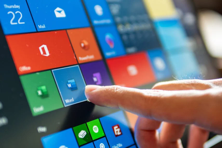 Close look of finger who point to the Microsoft Word Application on the laptop screen.
