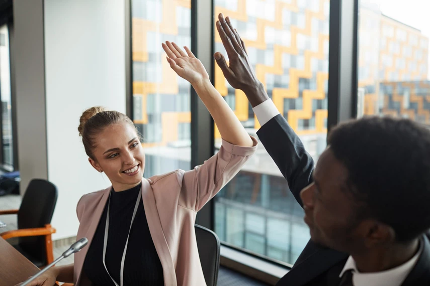 Man nad Women make high five in the office.