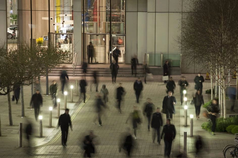 People walk in front of the hotel at night.