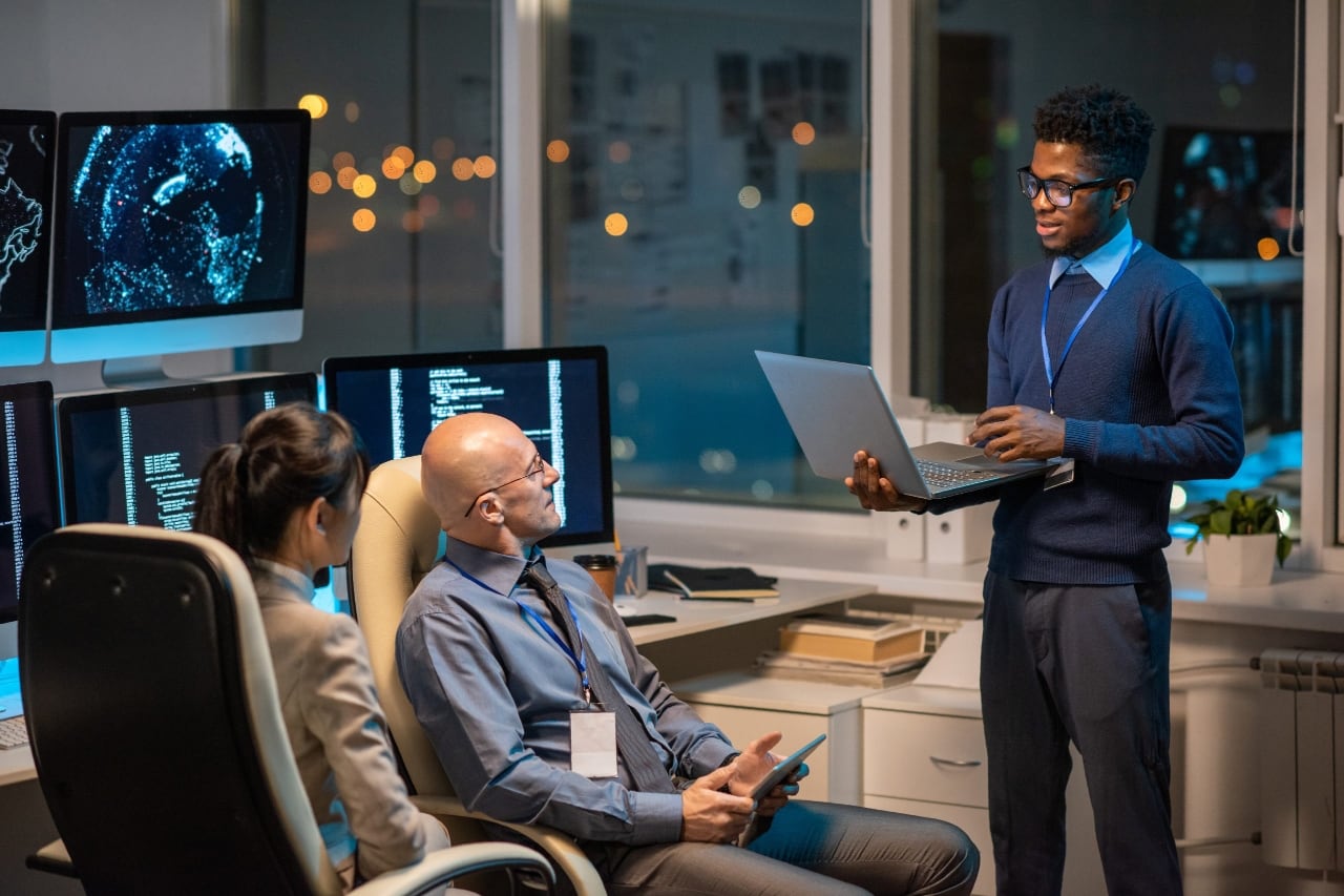 Young successful businessman with laptop making presentation for colleagues.